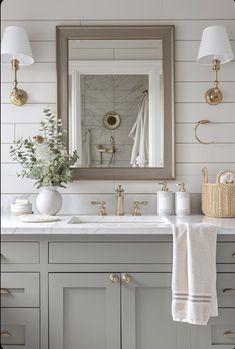 a bathroom sink with a mirror above it and towels hanging on the wall next to it