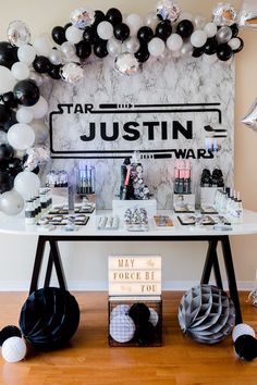 a star wars themed birthday party with balloons and decorations on the table, including black and white decor