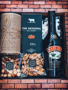 a bottle of booze and nuts in a gift box on a brick wall background