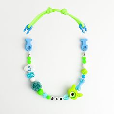 a green and blue beaded necklace on a white background with the word ooh written in small letters