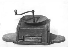 an old black and white photo of a stove with a frying pan on it