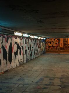 an empty parking garage with graffiti all over the walls