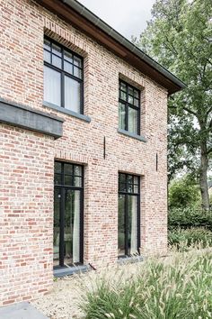 an exterior view of a brick house with large windows