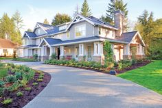 a large house with lots of windows in the front yard and landscaping on the side