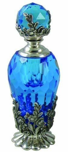 a blue glass bottle with an ornate design on the top and bottom, sitting in front of a white background