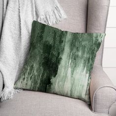 a green pillow sitting on top of a gray chair