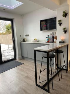 a kitchen with two bar stools next to a sliding glass door