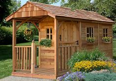 a small wooden shed sitting on top of a lush green field