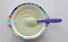 a spoon in a bowl filled with green dip