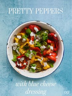 a white bowl filled with peppers and cheese on top of a blue tablecloth next to a