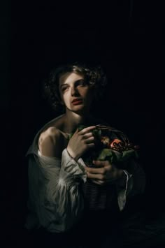 a woman is holding a basket in the dark