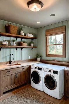 a washer and dryer in a room with green walls, wood floors and open shelving