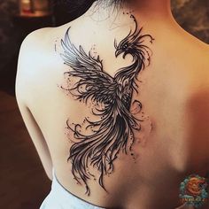 the back of a woman's neck with a bird tattoo on it