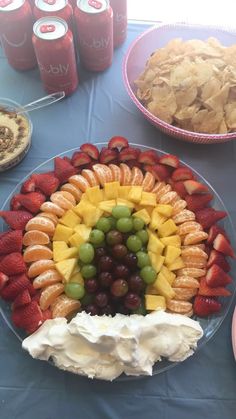 a platter filled with fruit and crackers on a table next to desserts