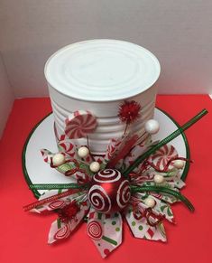 a white hat with candy canes and decorations on it sitting on top of a red table