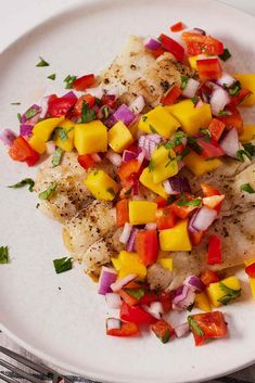 a white plate topped with fish and veggies