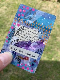 a hand holding up a small card with words on it that say stay the course