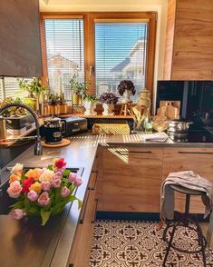 a kitchen filled with lots of counter top space and flowers in the middle of it