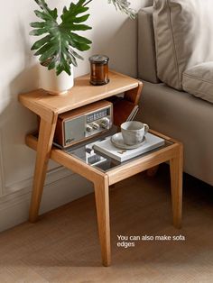 a wooden table with a radio on it and a potted plant next to it