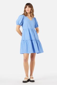 Blue mini smock dress, with a sweet v neckline. Featuring a two tier skirt, short puff sleeves & made of a cotton viscose blend. - slip on this easy relaxed style smock- soft v neckline with a sweet puff sleeve- mini length featuring a tiered skirt with exposed ruffle- handy side pocket- elastic hem on sleeve- side ties to cinch in at waist- made of a smooth viscose cotton blend- available in cornflower Product Code: PGFY141 Skirt Short, Smocked Dress, Cotton Viscose, Dress 16, Cornflower Blue, Tier Skirt, Smock Dress, Tiered Skirt, Relaxed Style