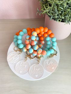 a white plate topped with lots of different colored beads next to a potted plant