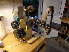 a machine that is sitting on top of a wooden table next to a lamp and other items