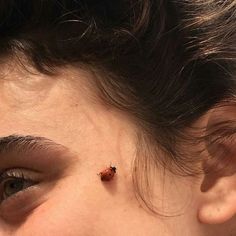 a lady bug crawling on the side of a woman's face