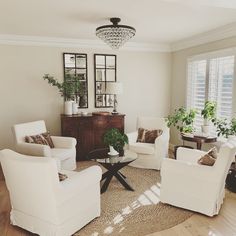 a living room filled with white furniture and lots of windows