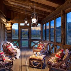 a porch with wooden furniture and large windows