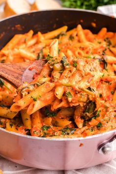 a pan filled with pasta and vegetables on top of a table