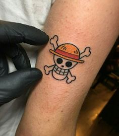 a person with a hat and skull tattoo on their arm