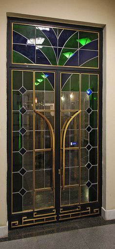 a large glass door with an intricate design on the front and side panels in gold