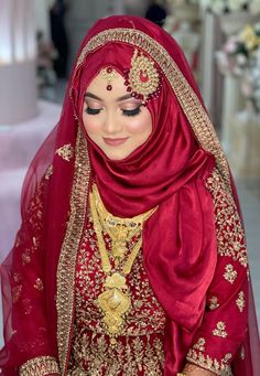 a woman wearing a red and gold wedding outfit