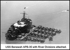 an aerial view of a ship in the water with many smaller boats around it,