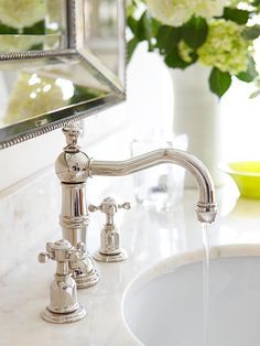 a bathroom sink with a faucet running water from it's spout