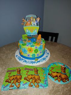 a birthday cake with the theme of scooby and friends on it sitting on top of a table