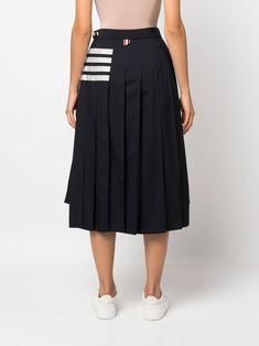 Indulge in the timeless elegance of this navy blue striped skirt, a true masterpiece in the world of high fashion. Made with the finest wool and featuring delicate pleats, this skirt exudes sophistication and class like no other. The side buckle fastening at the waist adds a modern touch to its traditional silhouette, while the high-low hem detail brings a unique and contemporary element. Whether you're dressing it up for a special occasion or adding a touch of luxury to your everyday look, this Thom Browne Women, Blue Striped Skirt, Printed Pleated Skirt, Striped Skirt, Dress Watch, Stripe Skirt, Blue Wool, Emilio Pucci, Plain Weave