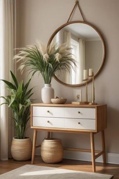 a white dresser with a mirror and potted plants on it in front of a window