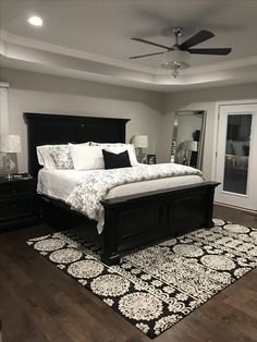 a bedroom with a bed, dressers and ceiling fan in the middle of it