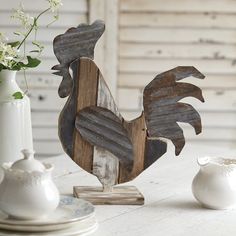 a wooden rooster statue sitting on top of a white table