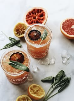 grapefruit, orange and sage spritkled cocktails on a marble table