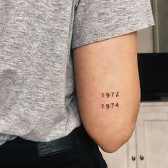 a person with a tattoo on their arm that reads, 1917 - 1974 written in small letters