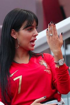 a woman in a red shirt is holding her hand up