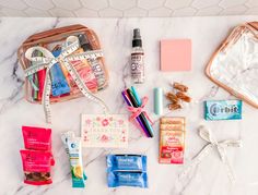 the contents of a travel bag laid out on a marble counter top, including toiletries and other items