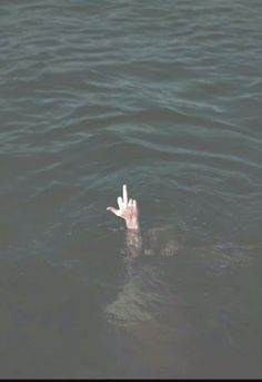 a person floating in the water with their hand out