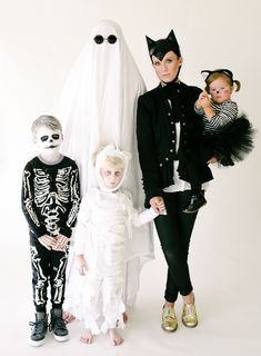 three children in costumes standing next to each other and posing for the camera with their parents