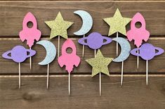 there are many cupcake toppers with stars and moon on them in the shape of rockets