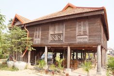 an old wooden building with people standing outside