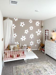 a baby's room with flowers painted on the wall and a crib in the corner