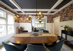 a dining room table with blue chairs and a chandelier hanging from the ceiling